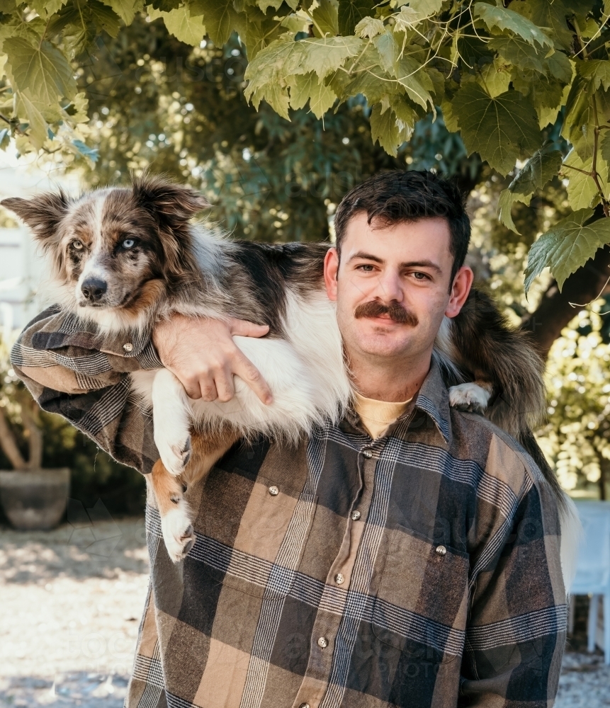 Man with a dog on his shoulders. - Australian Stock Image