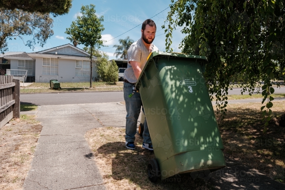 Man with Down Syndrome Retreiving Wheely Bin - Australian Stock Image