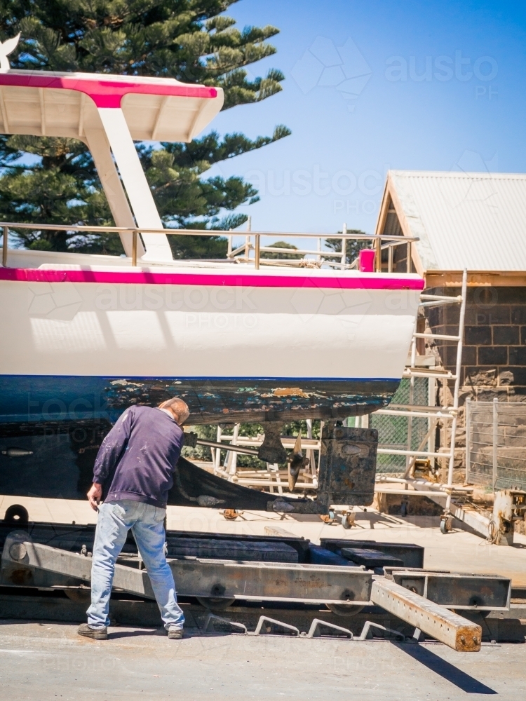 Man working on a wooden boat - Australian Stock Image