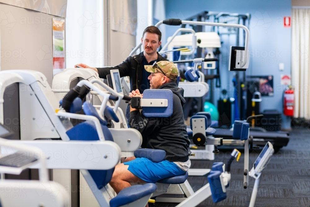 Man working on exercise therapy equipment at physiotherapist clinic - Australian Stock Image