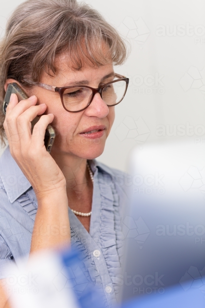 Mature business woman holding phone to ear - Australian Stock Image