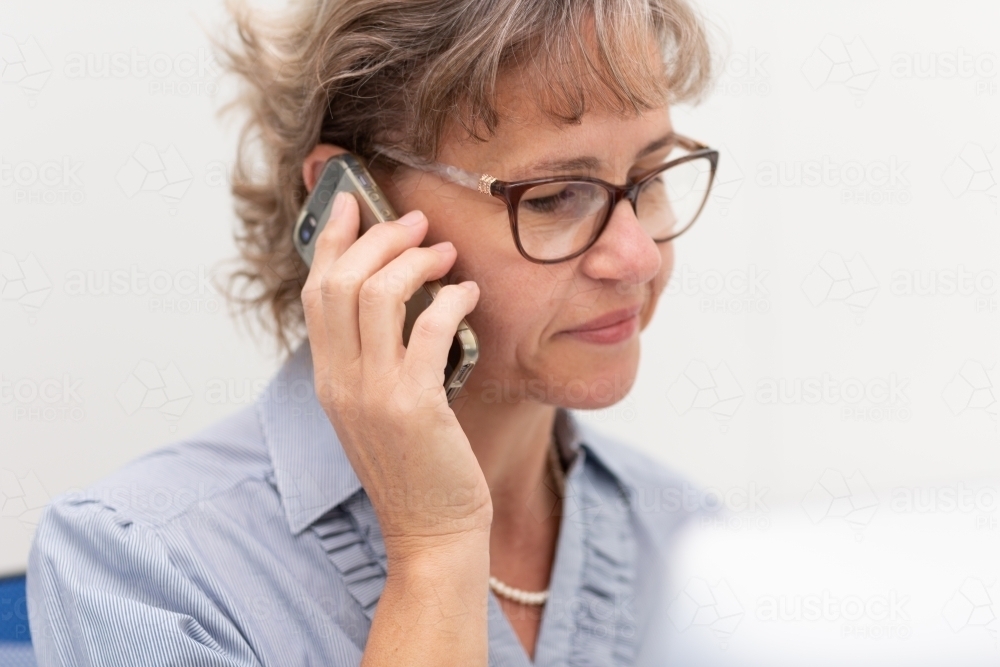 Mature business woman holding phone to ear - Australian Stock Image