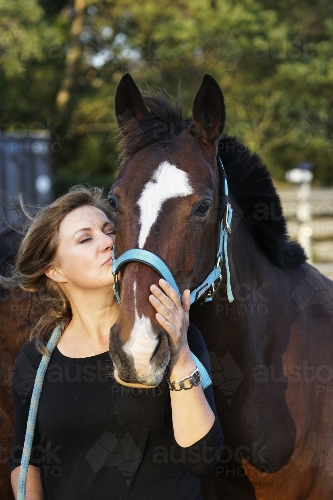 Mature woman standing with horse - Australian Stock Image