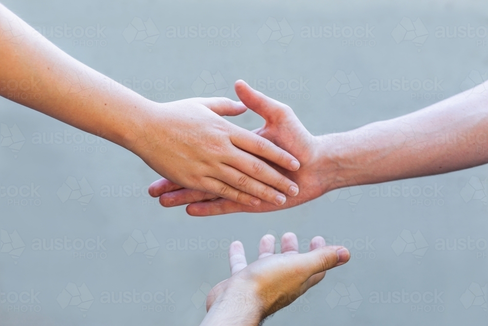 mediation concept - hands shaking in agreement with mediator - Australian Stock Image