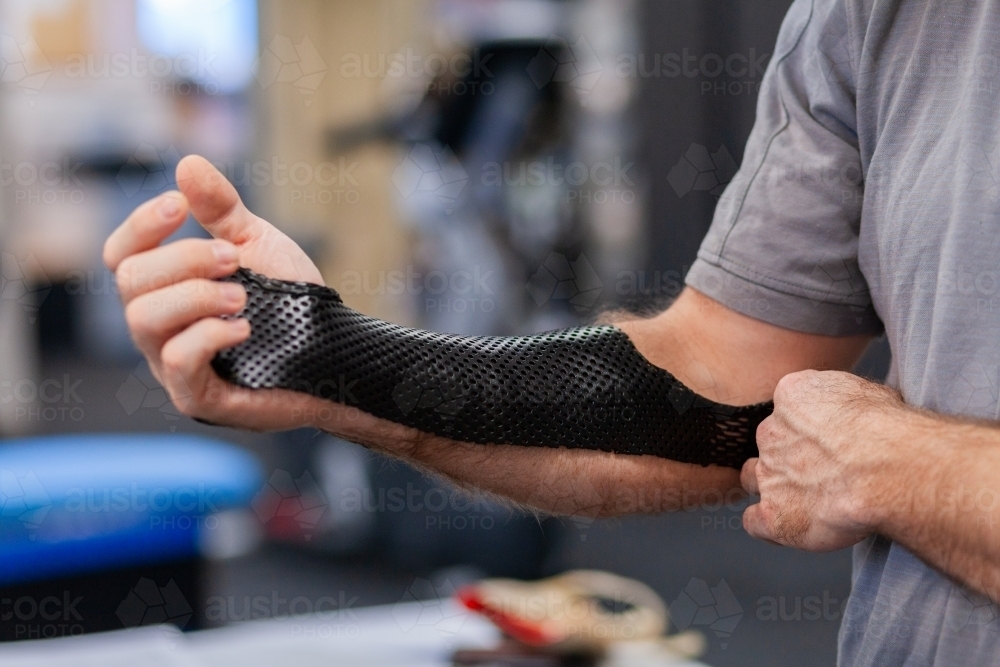 Medical brace on arm of man at physio - Australian Stock Image