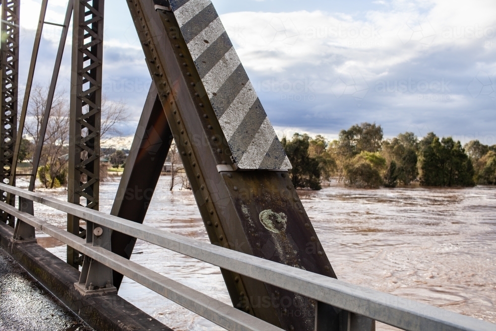 metal beam of bridge with flooding Hunter River rising up close - Australian Stock Image