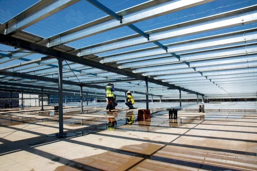 Metal framework and workers on an industrial building site - Australian Stock Image