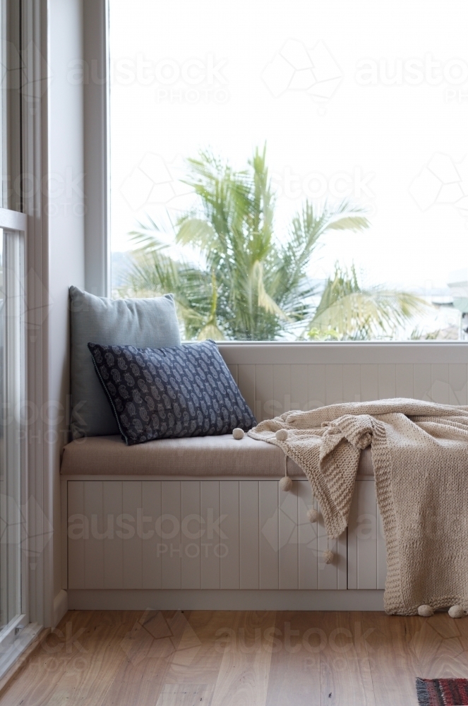 Window seat with cushions and draped blanket - Australian Stock Image