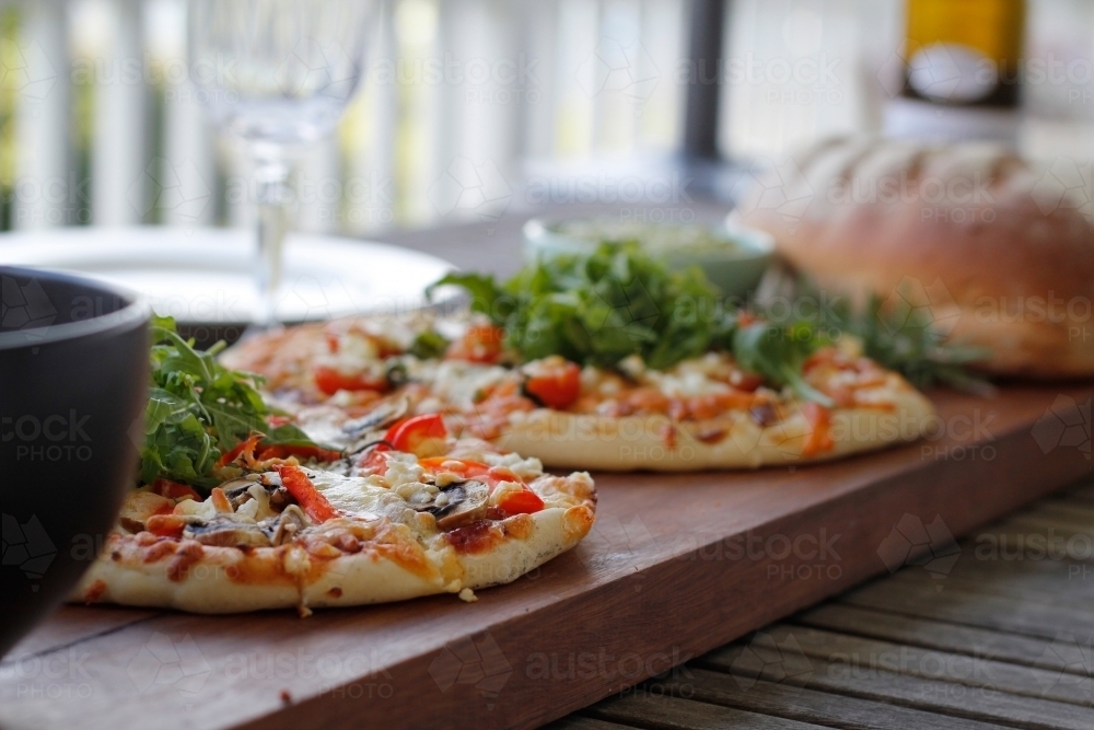 Homemade pizzas on wooden serving board - Australian Stock Image