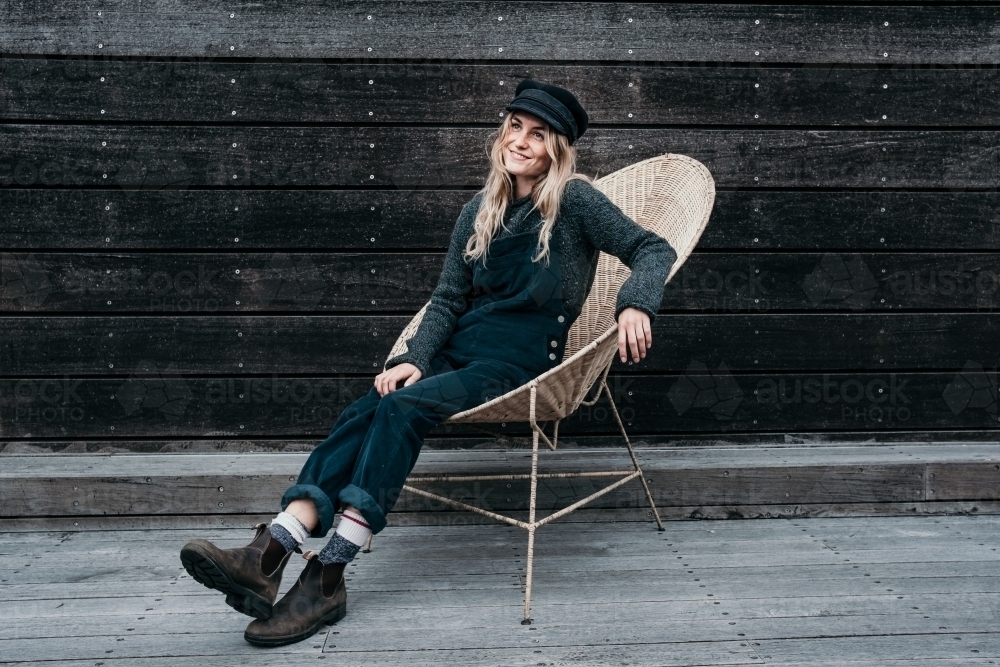 Mid twenties woman sitting in a chair relaxing. - Australian Stock Image