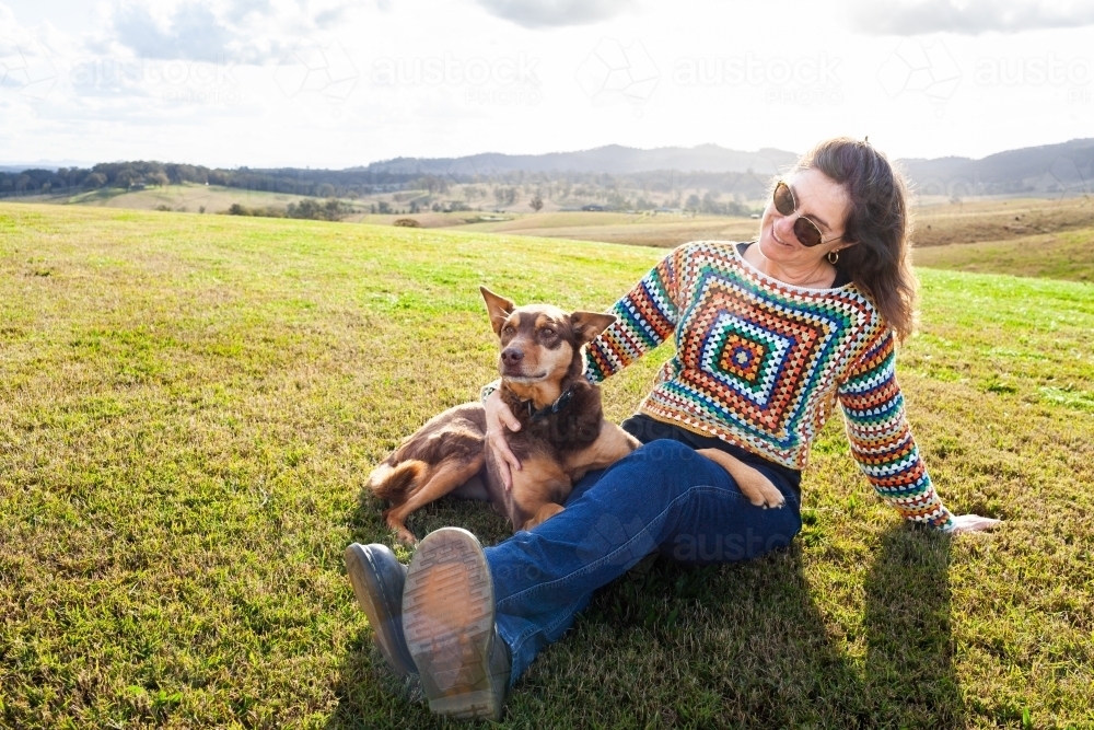 image-of-middle-age-country-woman-relaxing-on-green-lawn-grass-with-her