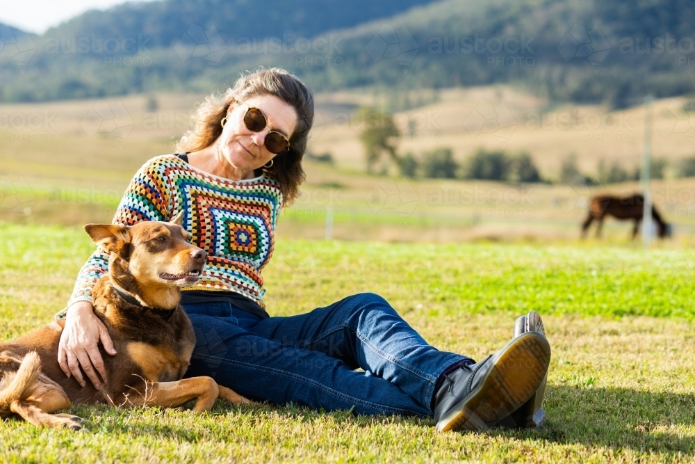 image-of-middle-age-country-woman-relaxing-on-green-lawn-grass-with-her