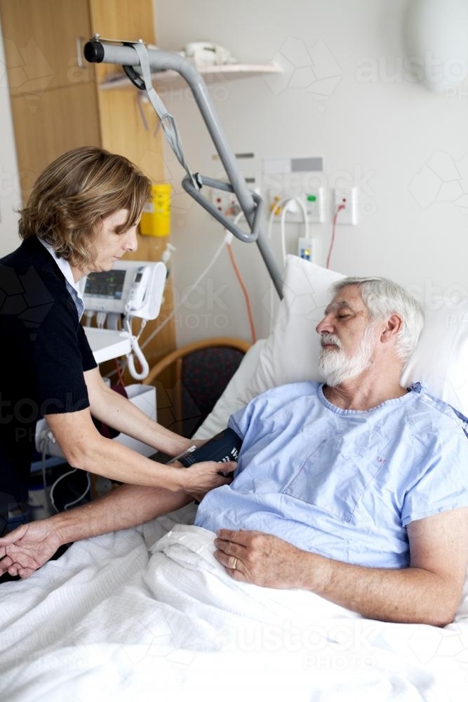 Middle aged male patient being treated by a nurse in a hospital ward - Australian Stock Image