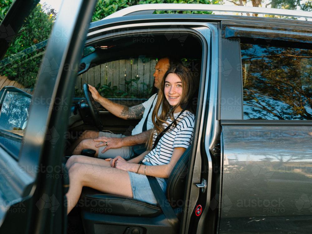 Middle-aged man and young teenage girl sitting inside the car. - Australian Stock Image