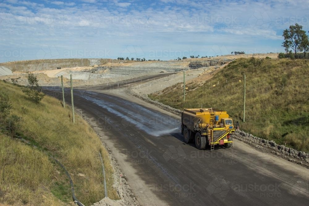 Mine truck spraying the roads with water to minimise dust - Australian Stock Image