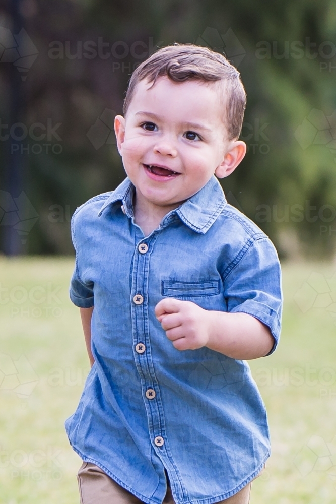 Mixed race aboriginal caucasian boy running laughing - Australian Stock Image