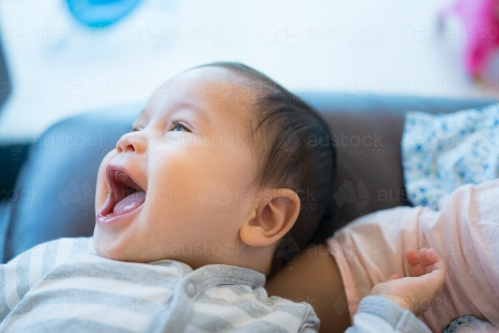 Mixed race baby boy laughing at home - Australian Stock Image