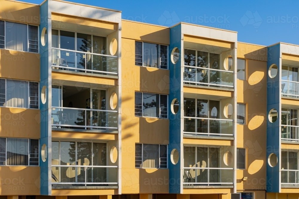 Modern building facade with circular cut outs and unusual shadow patterns - Australian Stock Image