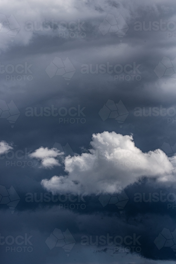 Moody clouds with one white cloud - Australian Stock Image