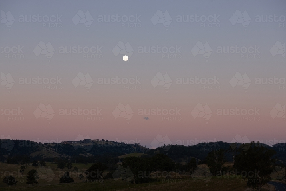 Moon rising over landscape - Australian Stock Image