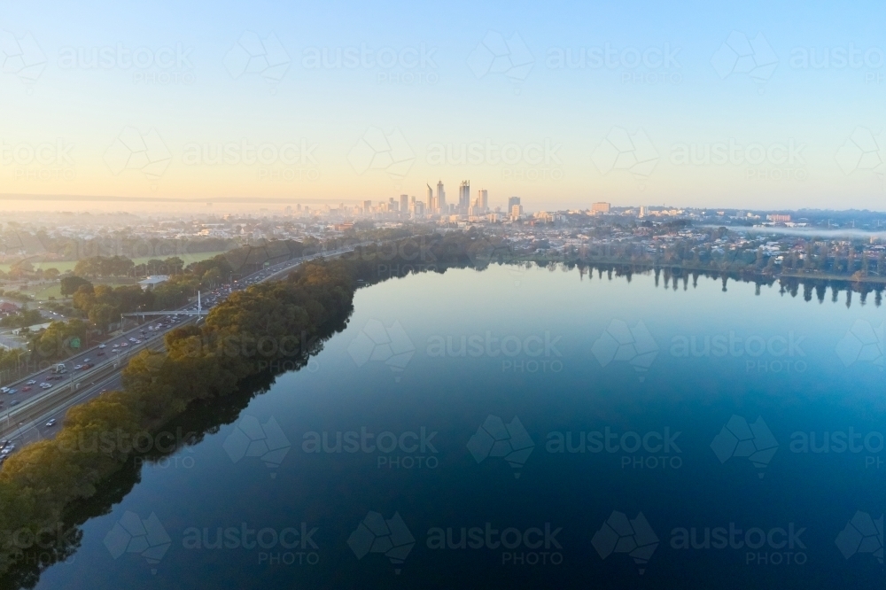 Morning aerial view over Lake Monger with the foggy Perth City skyline and the Mitchell Freeway - Australian Stock Image