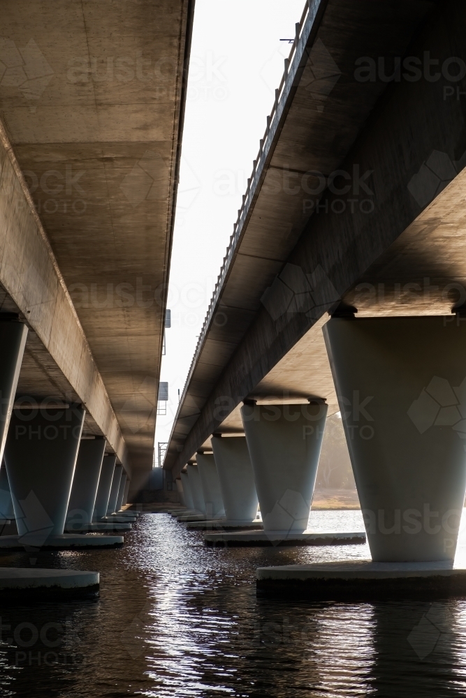 Morning sun shining underside of concrete bridge on Swan River - Australian Stock Image