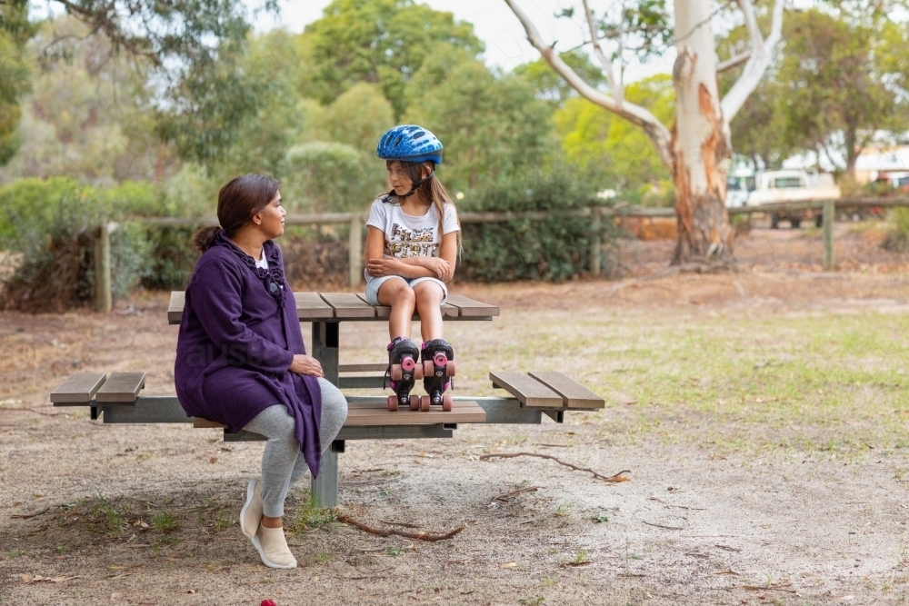 mother and child sitting at park table - Australian Stock Image