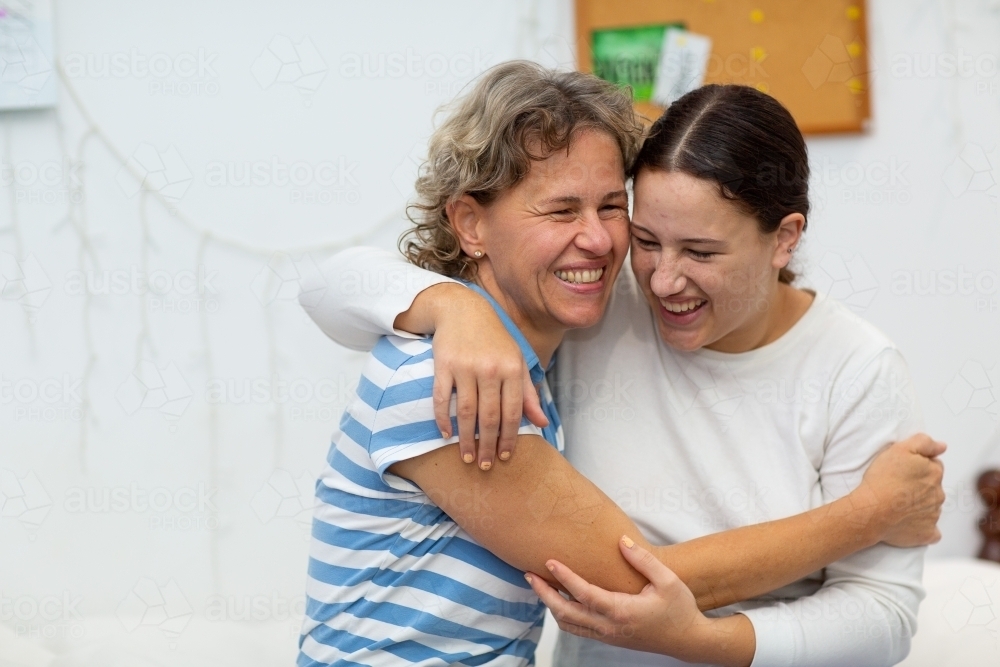 Mother and daughter laughing and hugging - Australian Stock Image