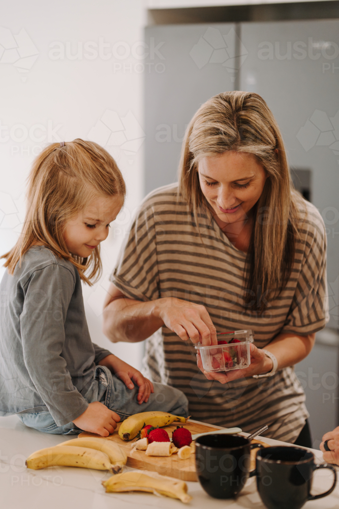 Mother and daughter prepares food in the kitchen. - Australian Stock Image