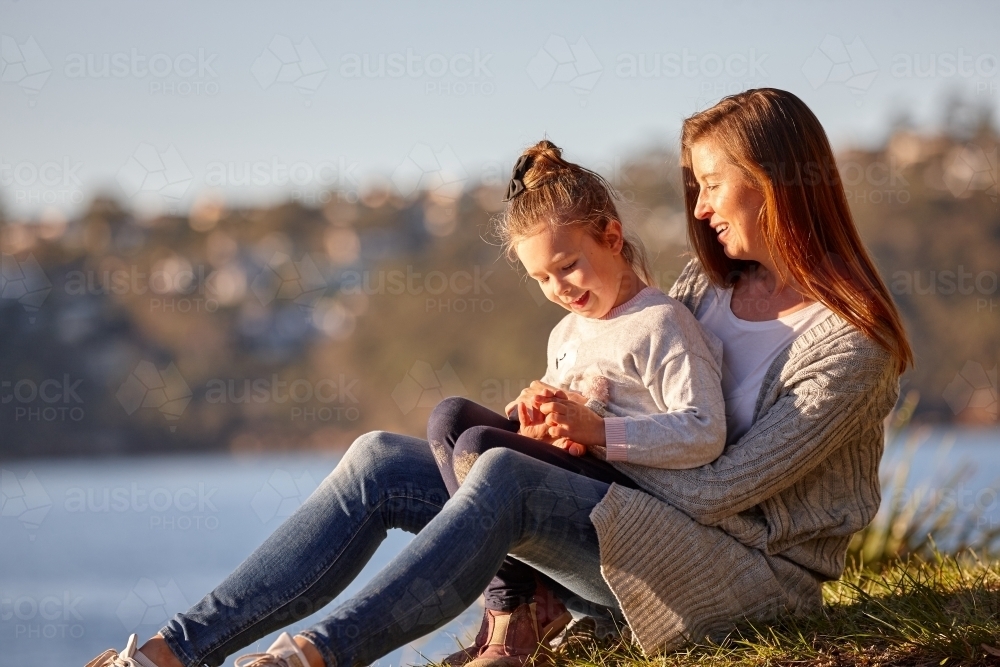 Mother and daughter sharing time together at headland over ocean - Australian Stock Image