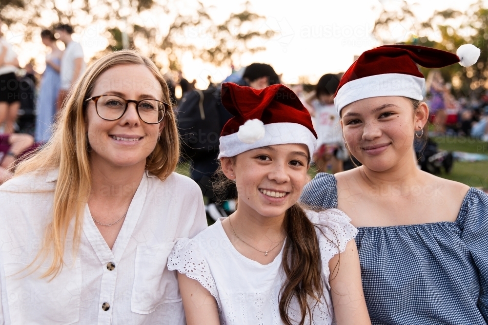 mother and her teenage daughters at a Christmas community event - Australian Stock Image