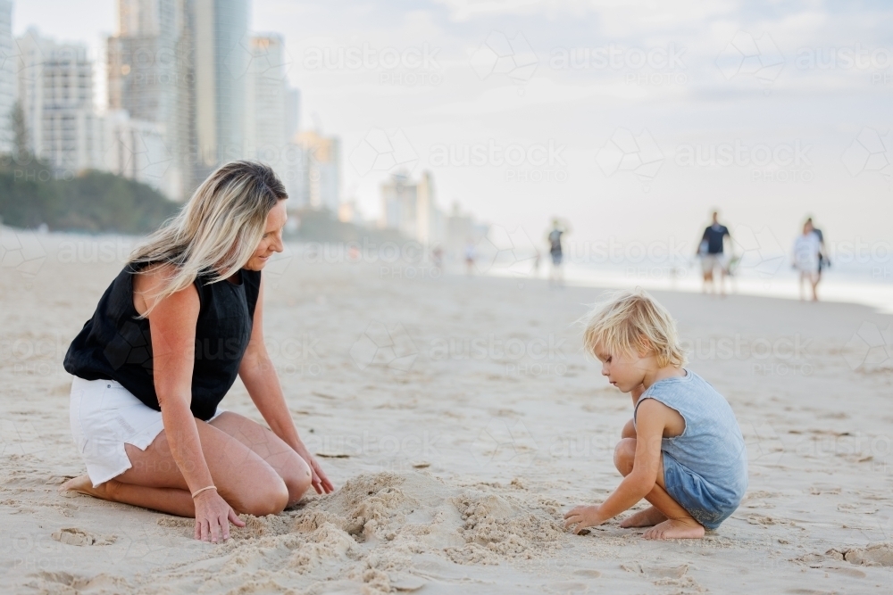 Mother and son playing in the sand on Main Beach at Surfers Paradise on the Gold Coast - Australian Stock Image