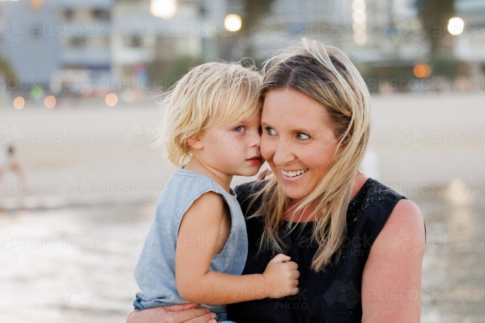 Mother and son snuggling on the beach - Australian Stock Image