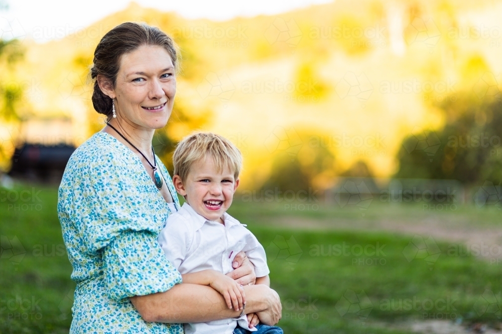 Mother hugging young son outside - Australian Stock Image