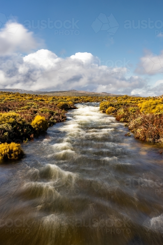 Mountain stream with sky in background - Australian Stock Image