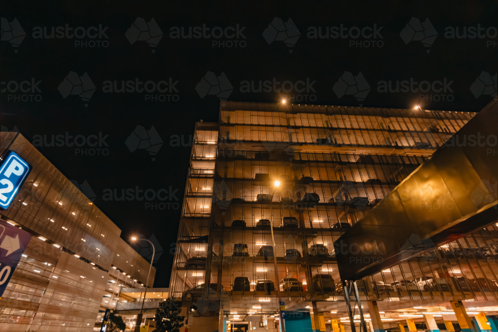 Multi story car park at the Sydney Domestic Airport illuminated at night - Australian Stock Image