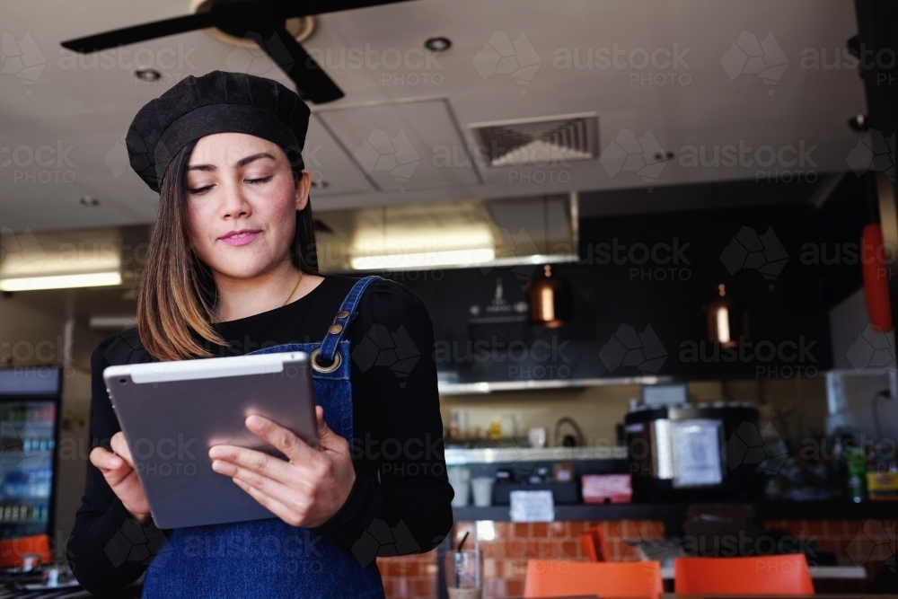 Multicultural Asian waitress taking order at Thai restaurant - Australian Stock Image