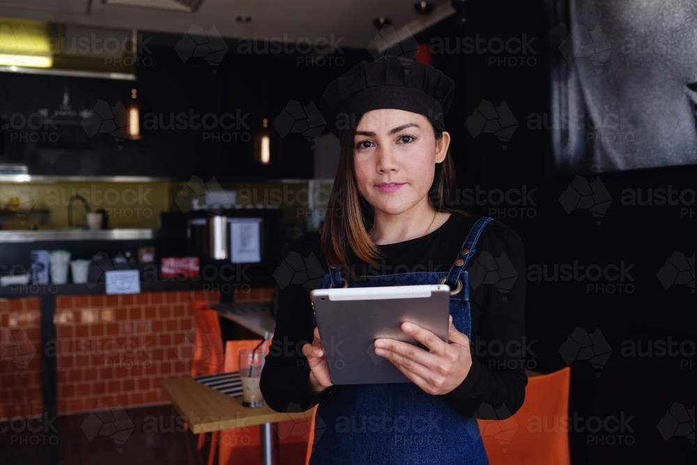 Multicultural Asian waitress taking order at Thai restaurant - Australian Stock Image