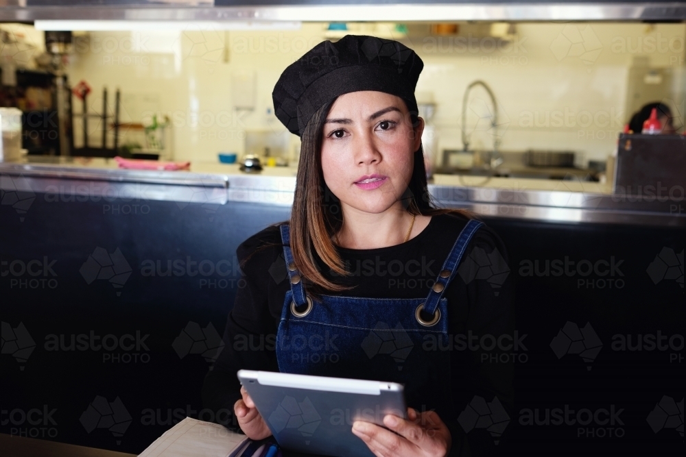 Multicultural Asian waitress taking order at Thai restaurant - Australian Stock Image