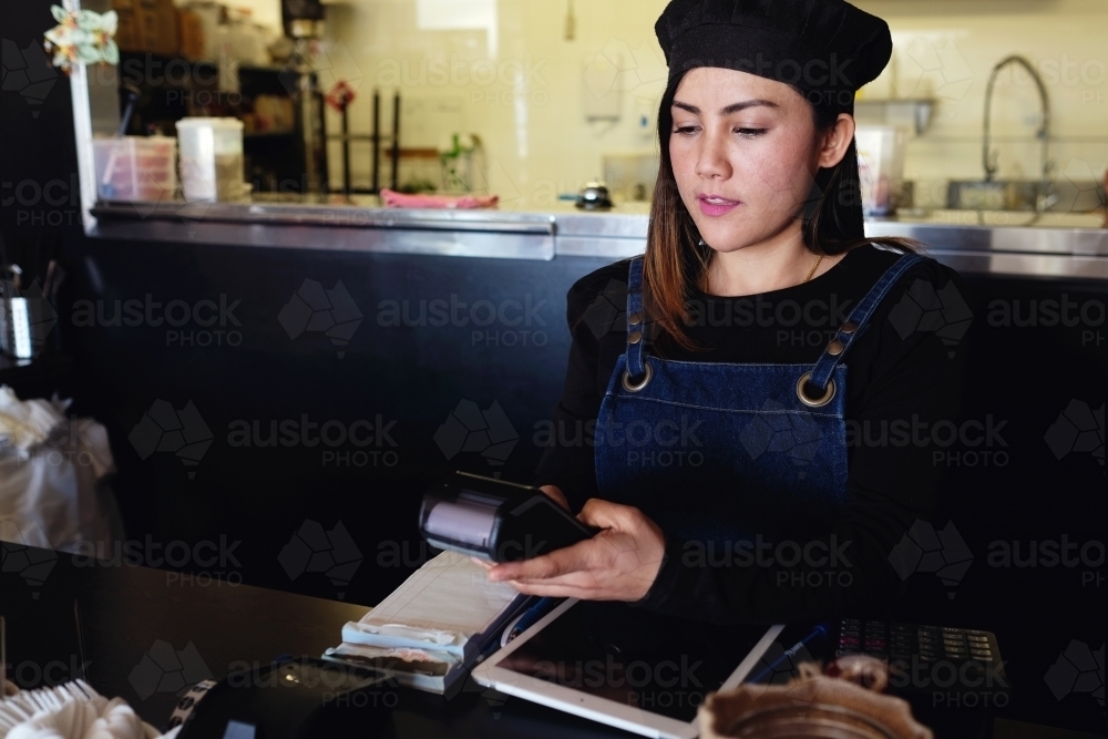 Multicultural Asian waitress taking order at Thai restaurant - Australian Stock Image