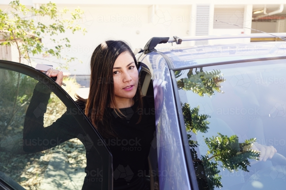 Multicultural Asian woman getting in the car - Australian Stock Image