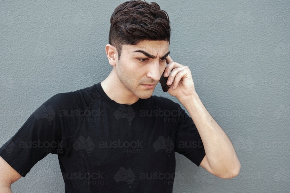 multicultural young adult man on the phone - Australian Stock Image