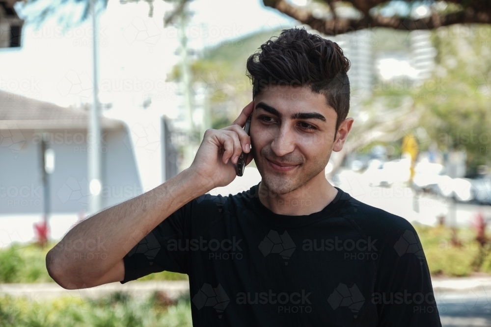 multicultural young adult man on the phone - Australian Stock Image