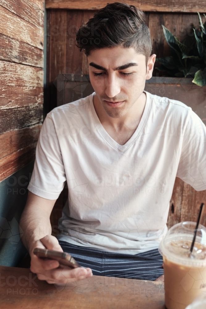 multicultural young adult man using smartphone - Australian Stock Image