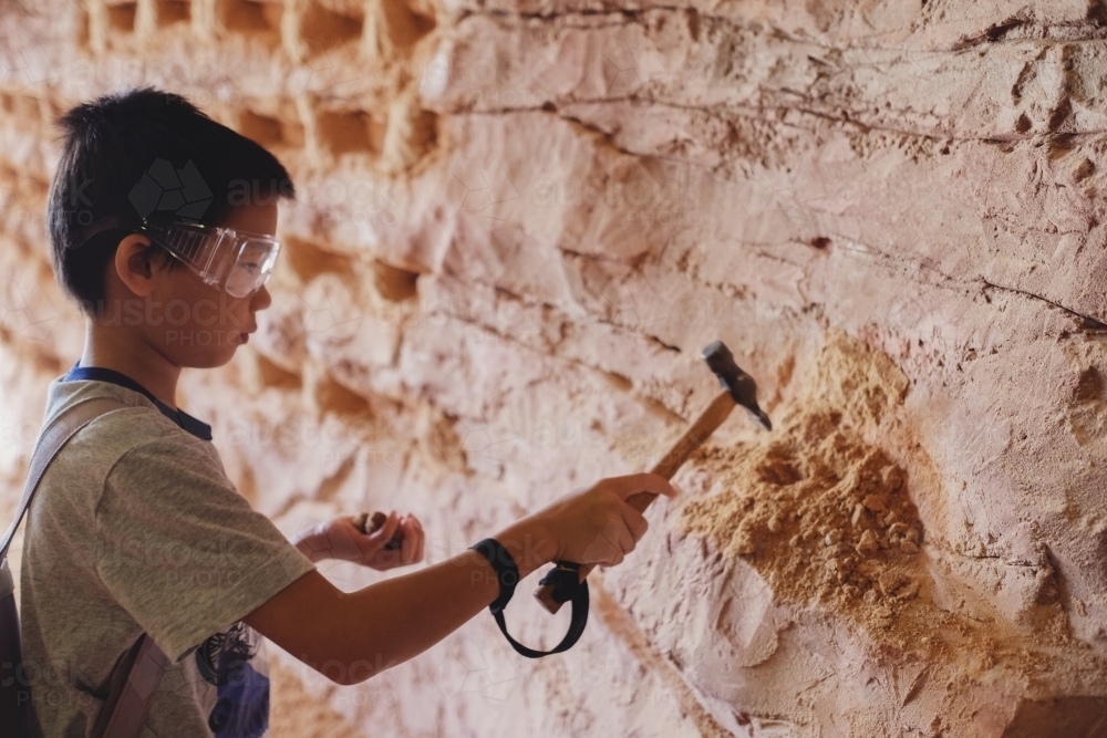 image-of-multiethnic-young-boy-chipping-away-at-the-mine-wall-having