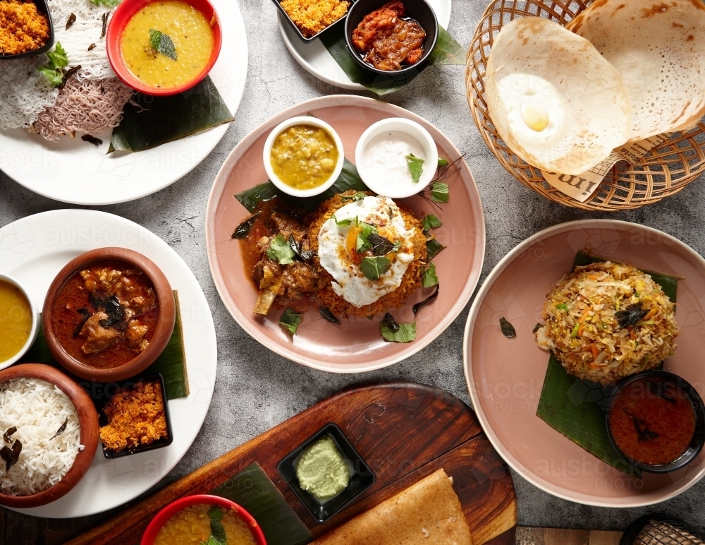 Multiple Indian food dishes on table - Australian Stock Image