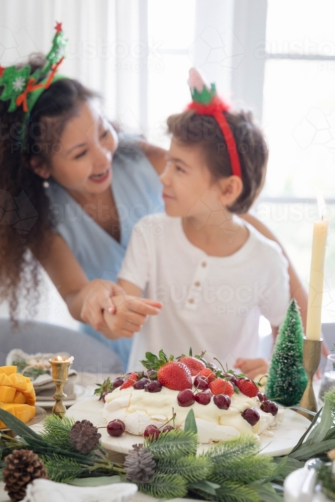 Mum and son wearing Christmas headbands at the table - Australian Stock Image