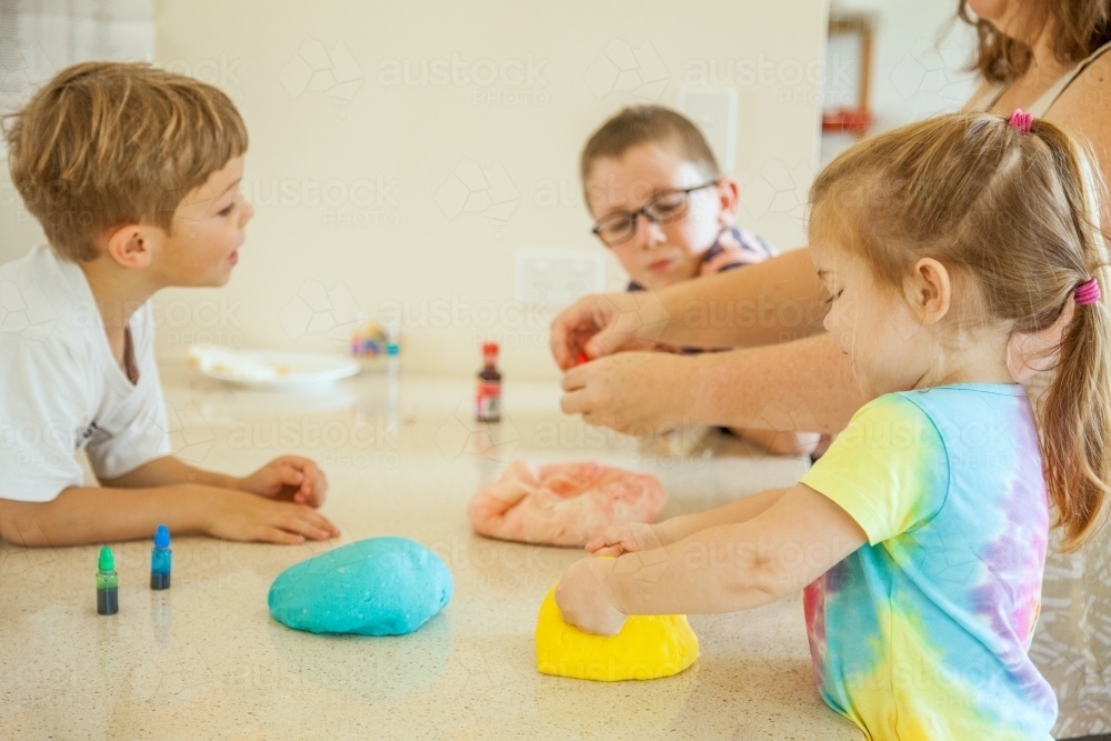 Mum making colourful play dough with her kids - Australian Stock Image