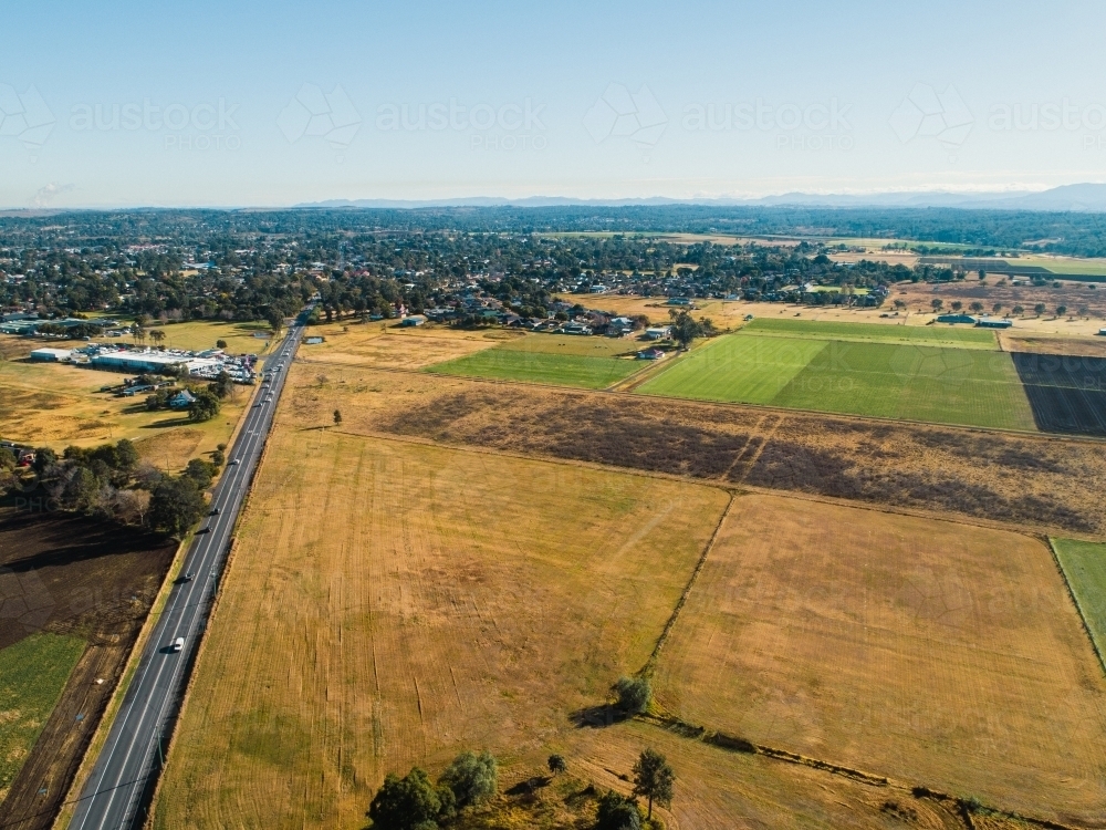 New England Highway entering Singleton with farmland beside  road - Australian Stock Image