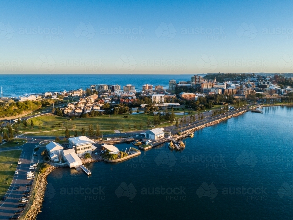 Newcastle Harbour at sunset with last light on seaside buildings on the foreshore - Australian Stock Image